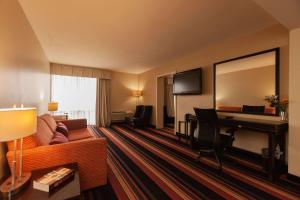 ケナーにあるClarion Hotel New Orleans - Airport & Conference Centerのソファとデスクが備わるホテルルームです。