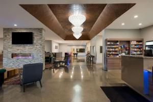 a living room with a fireplace and a stone wall at Richland Riverfront Hotel, Ascend Hotel Collection in Richland