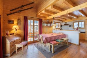 a kitchen and dining room with a table in a cabin at Montebello Cozy, classic Swiss chalet with stunning views in La Tzoumaz