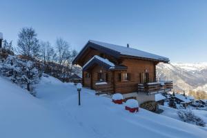 een blokhut in de sneeuw met sneeuw bij Montebello Cozy, classic Swiss chalet with stunning views in La Tzoumaz