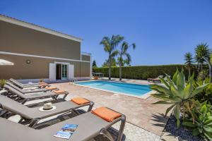 a villa with a swimming pool and patio furniture at Villa Teotel by Villa Plus in Almancil