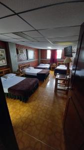 a room with four beds in a room with at HOTEL DEL PARQUE in Calarcá