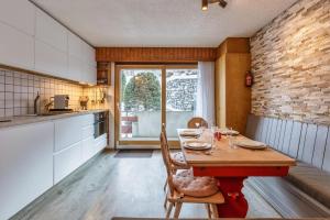 a kitchen with a table and chairs in a room at Nev 404 Centrally located 6 pax apartment and garage in La Tzoumaz