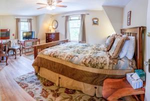 a bedroom with a large bed and a living room at Heathwood Inn in Bar Harbor