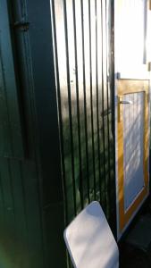 un inodoro blanco sentado frente a una puerta en B&B boerderij rust, in pipowagens!, en Den Helder