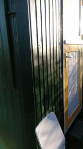 a white toilet sitting in front of a gate at B&B boerderij rust, in pipowagens! in Den Helder