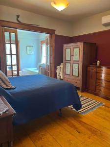 1 dormitorio con 1 cama azul y suelo de madera en Family and Friends in Historic Greenport House en Greenport