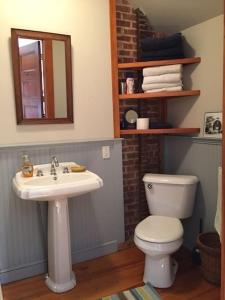 y baño con lavabo, aseo y espejo. en Family and Friends in Historic Greenport House en Greenport