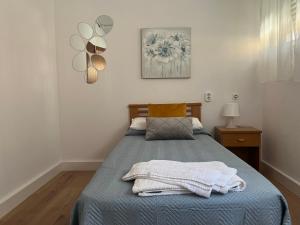 a bedroom with a bed with a blue blanket at RESISANTANDER - Apartamento para 9 personas in Santander