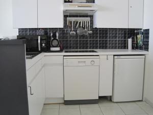 a kitchen with white cabinets and white appliances at Beachview Pier Blankenberge in Blankenberge