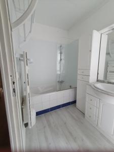 ein weißes Badezimmer mit einem Waschbecken und einem Spiegel in der Unterkunft Villa "Le Mirage" in Cap-Ferret