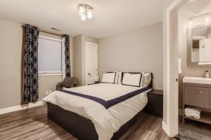 a bedroom with a large bed and a sink at Central Park - 28th Place Apt in Aurora