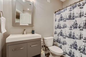 a bathroom with a toilet and a shower curtain at Central Park - 28th Place Apt in Aurora +21 photos