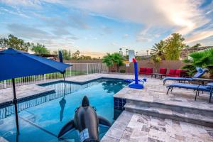 a swimming pool with a dolphin in the water at Pet-Friendly Glendale Home with Pool and Putting Green in Phoenix