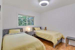 a bedroom with two beds and a window at Downtown Home with Patio - Walk to Shops and Dining! in Stevenson