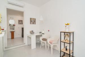 een witte woonkamer met een tafel en stoelen bij Maison 31 in Santa Marinella