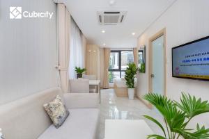 a living room with a couch and a tv at Cubicity Hidden House in Ho Chi Minh City