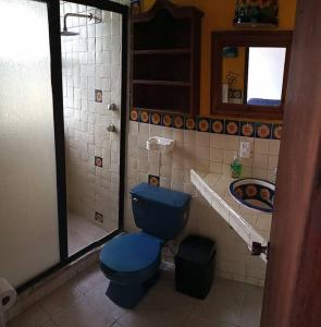 y baño con aseo azul y ducha. en Finca Taino. Hermosa casa con alberca en Jiutepec
