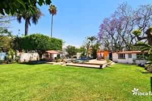 un patio con piscina y una casa en Finca Taino. Hermosa casa con alberca, en Jiutepec