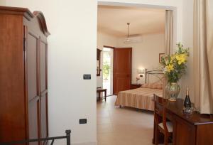 ein Schlafzimmer mit einem Bett und einer Vase aus Blumen auf einem Tisch in der Unterkunft Villa Cristina in Giardini-Naxos