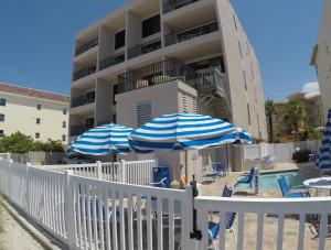 dos sombrillas y sillas azules y blancas y una piscina en Island Gulf Resort, a VRI resort, en St Pete Beach