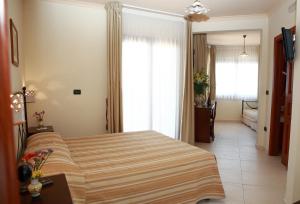 a bedroom with a bed with a striped blanket at Villa Cristina in Giardini Naxos