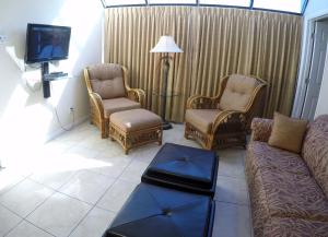 un soggiorno con divano, sedie e TV di Island Gulf Resort, a VRI resort a St Pete Beach