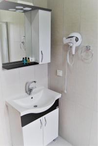 y baño con lavabo blanco y espejo. en BEYAZ KONAK Güre Butik Otel, en Edremit