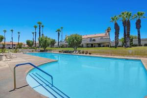 a large swimming pool with palm trees and a house at DL882 - Desert Falls Poolside Escape in Palm Desert
