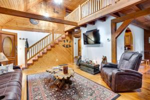 a living room with leather furniture and a wooden staircase at Orleans Retreat with Private Hot Tub and Fireplace! 