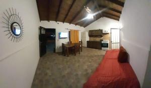 sala de estar con cama roja y cocina en Alquiler Galo en Mar del Plata