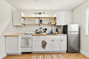 una cucina bianca con armadi bianchi e frigorifero di Modern Studio Apartment near Merrimack Park a Huntsville