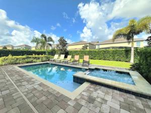 a swimming pool with chairs in a yard at Deluxe Stay w Pool Spa Game Room BBQ Grill in Orlando