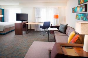 a hotel room with a couch and a bed and a desk at Residence Inn Portland Scarborough in Scarborough