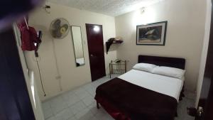 a bedroom with a bed and a bathroom with a mirror at HOTEL DEL PARQUE in Calarcá