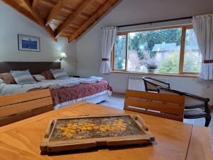 Un dormitorio con una cama y una mesa con una bandeja de fruta encima. en Las Golondrinas - UF 319, en San Martín de los Andes 22 fotos más