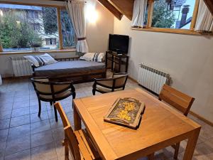 a living room with a table and a couch at Las Golondrinas - UF 319 in San Martín de los Andes