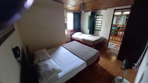 a small room with two beds and a window at HOTEL DEL PARQUE in Calarcá