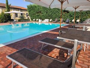 a swimming pool with two tables and an umbrella at Hotel Antica Tabaccaia Resort in Terranuova Bracciolini