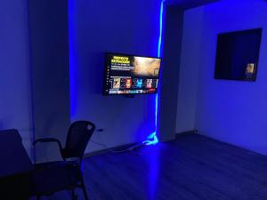 Pokój z jasnym niebieskim pokojem z krzesłem i telewizorem w obiekcie Habitación independiente a 5 min de fundidora w mieście Monterrey