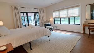 Un dormitorio con una cama, un escritorio y ventanas. en Bold Stump Cottage, en Lakeside
