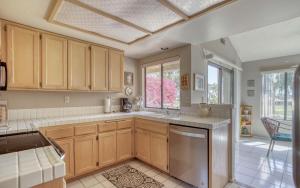 a kitchen with wooden cabinets and a large window at PY732 - Champion Haven - Meredith Lodging in Palm Desert