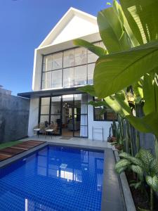 a house with a swimming pool in front of it at Casa Terra in Batu