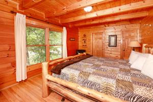 a bedroom with a bed in a log cabin at Thunder Mountain in Sevierville +57 photos