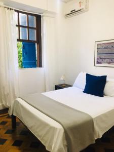 1 dormitorio con 1 cama blanca grande y ventana en Pousada Estrela do Mar, en Salvador