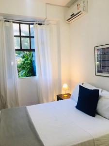 a bedroom with a white bed and a window at Pousada Estrela do Mar in Salvador