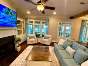 a living room with a blue couch and a flat screen tv at Drake on the Lake - False River, LA 