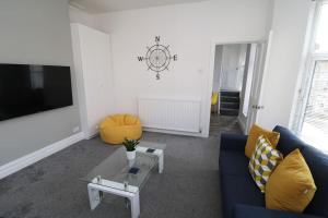 a living room with a blue couch and a tv at Modern 3 Double Bedroom Town Centre Maisonette in Morecambe