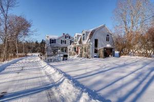a large house in the snow with a driveway at 3 Bedroom 2 Bath Carriage House (Pet Friendly) in Bar Harbor