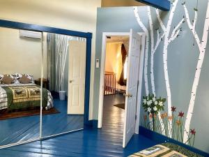 a bedroom with a bed and a door with a tree mural at 3 Bedroom 2 Bath Carriage House (Pet Friendly) in Bar Harbor